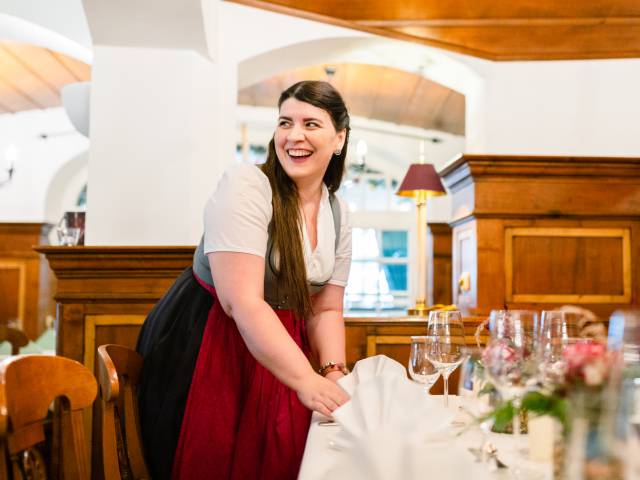 Kellnerin deckt Tisch im Restaurant ein