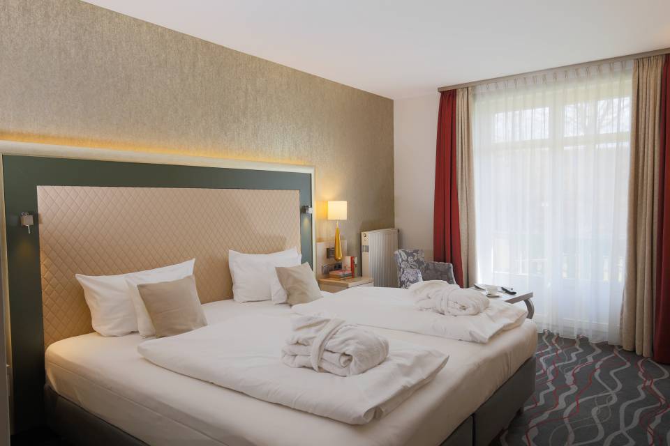 Hotelzimmer mit Doppelbett und Bademäntel